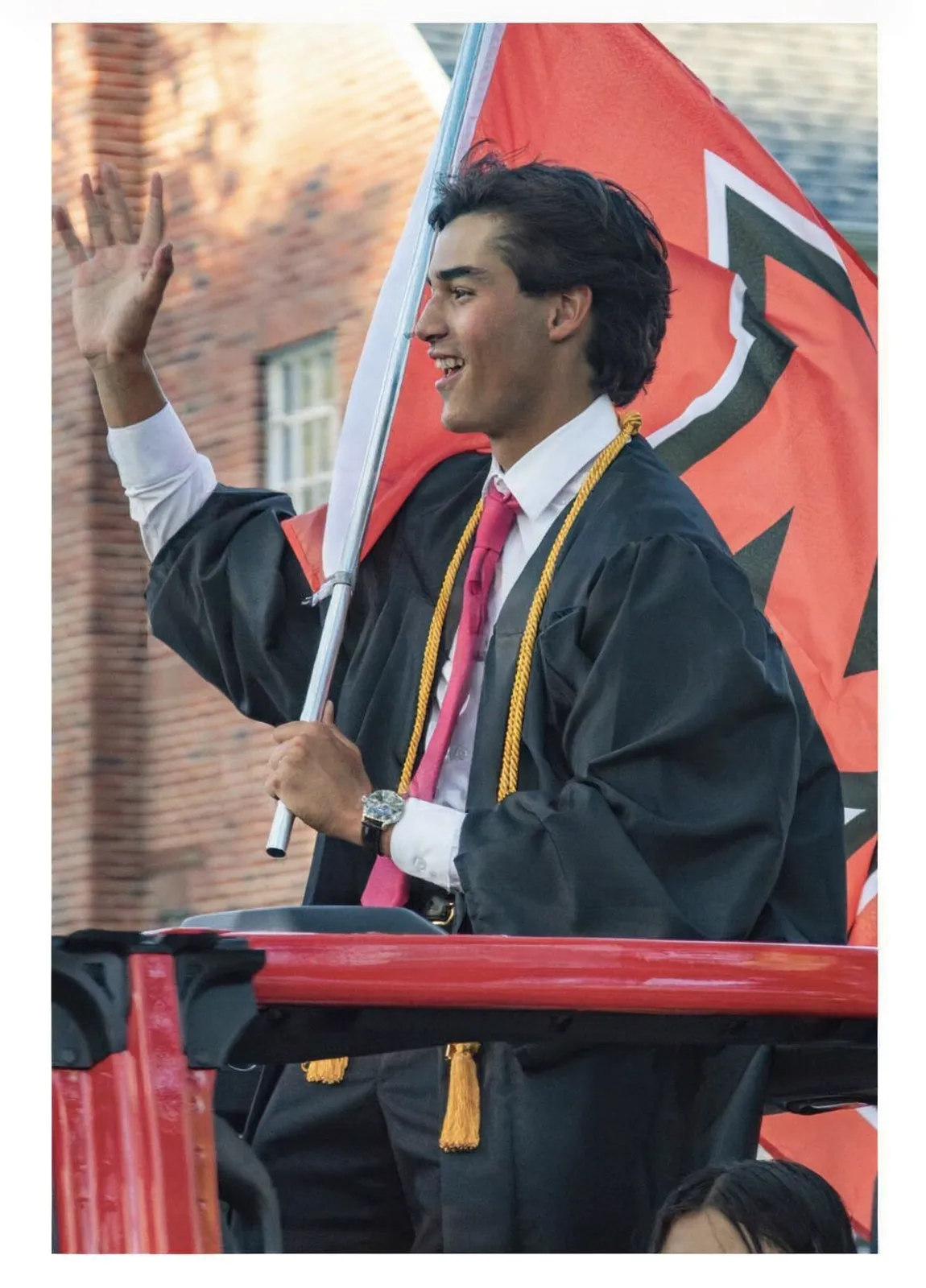 Avi Hanusz waving from a float at his Ottawa Hills graduation